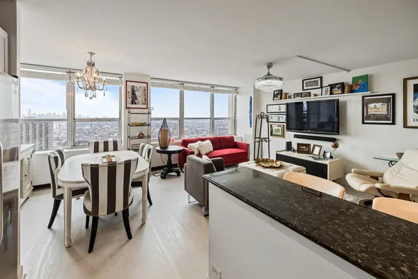 a living room with furniture a flat screen tv and a dining table