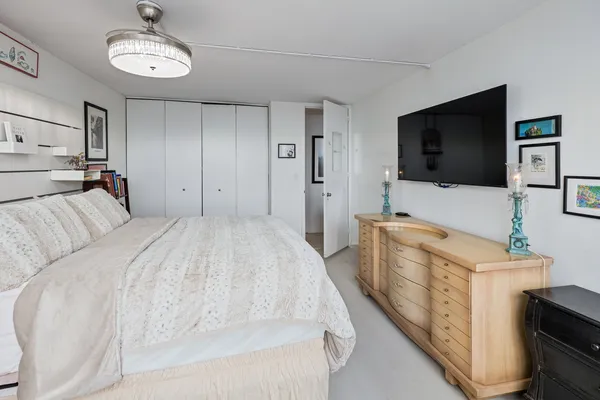 a spacious bedroom with a bed and a flat screen tv