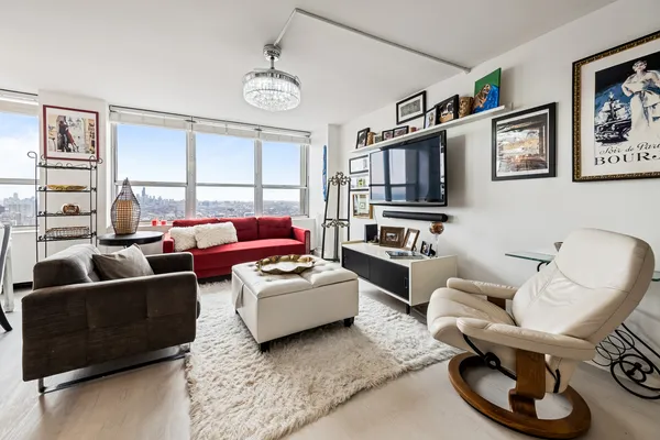 a living room with furniture a flat screen tv and a window