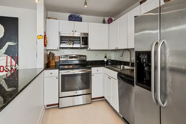 a kitchen with stainless steel appliances and white cabinets