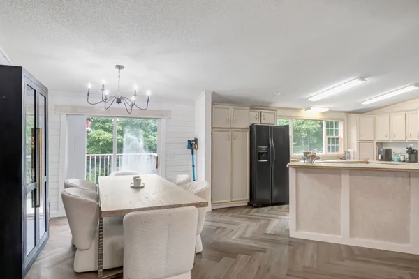 a dining room with stainless steel appliances granite countertop furniture and a kitchen view