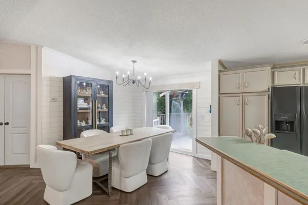 a view of a dining room with furniture a chandelier and wooden floor