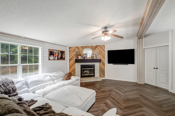 a living room with furniture a fireplace and a flat screen tv