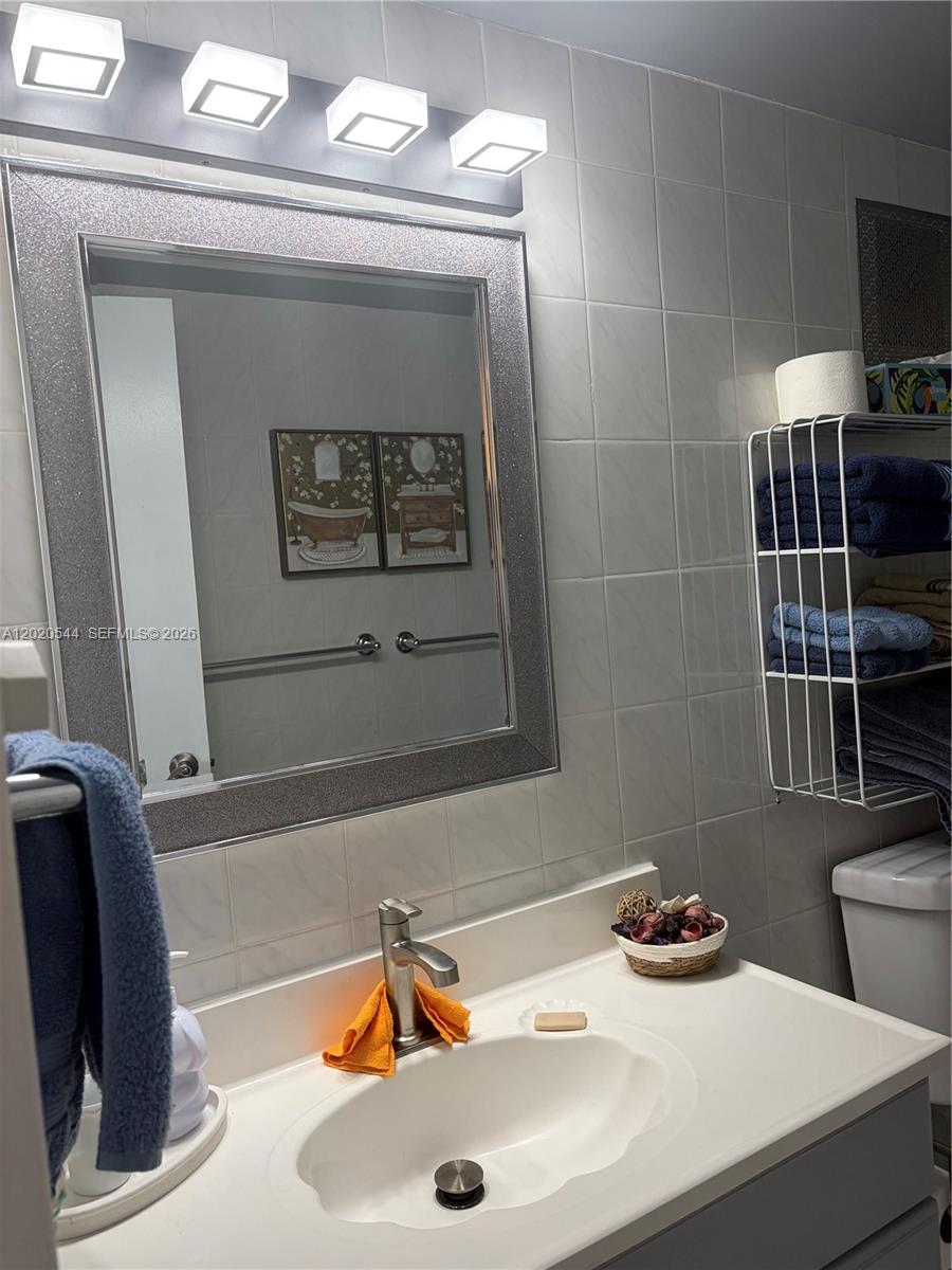 1913 South Ocean Drive, Unit 427 Hallandale Beach, FL 33009 - Photo 10 of 16 a bathroom with a sink a toilet and a mirror
