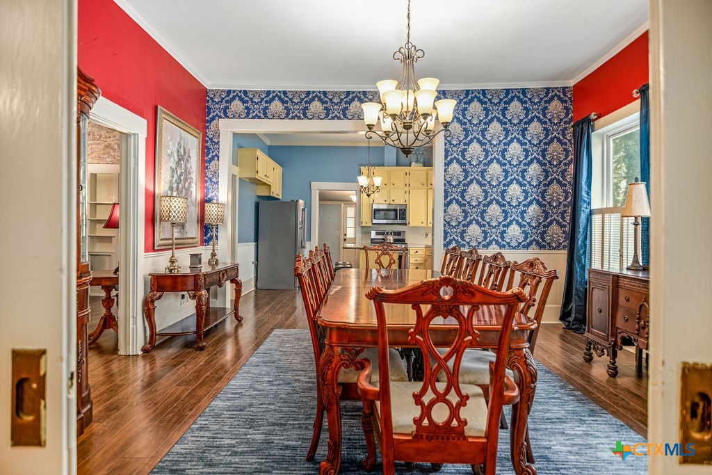 407 Robinson Street Edna, TX 77957 - Photo 11 of 41 a view of a dining room with furniture wooden floor and chandelier