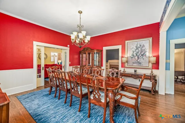 a view of a dining room with furniture wooden floor and chandelier