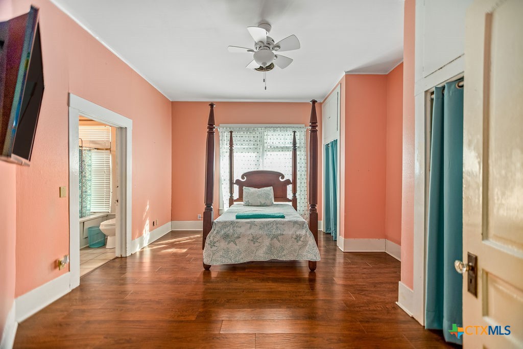 407 Robinson Street Edna, TX 77957 - Photo 25 of 41 a hallway with wooden floor a chandelier fan and windows