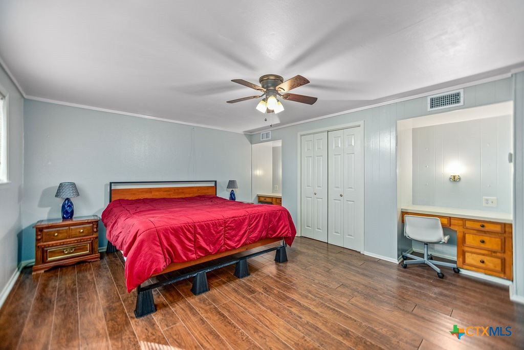 407 Robinson Street Edna, TX 77957 - Photo 30 of 41 a bedroom with a bed and a chandelier