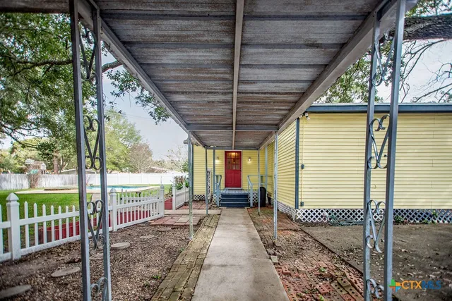 a porch with a table and chairs next to a yard