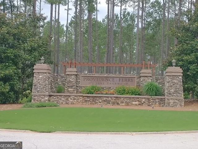 a green field with lots of trees in the background