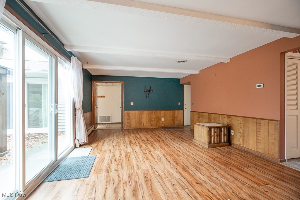 2969 Center Road Avon, OH 44011 - Photo 12 of 33 Family room with beamed ceiling, hardwood / wood-style floors, and wooden walls