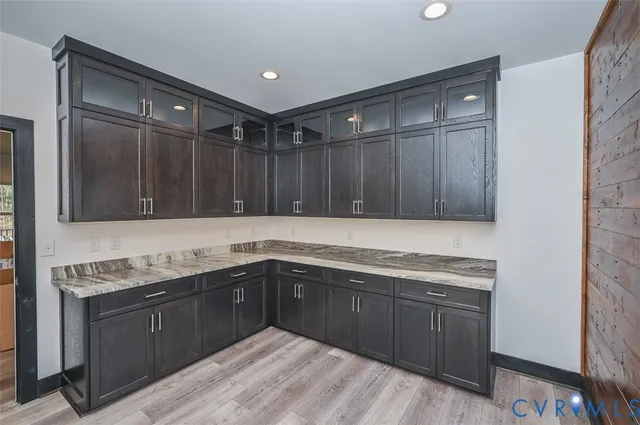 an empty room with wooden floor and a ceiling fan