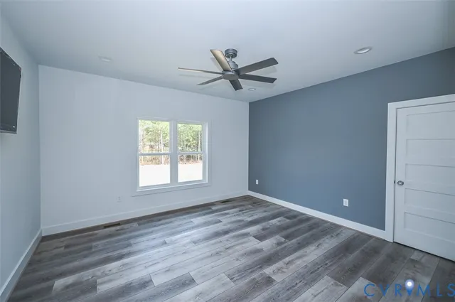 a view of empty room with window and ceiling fan