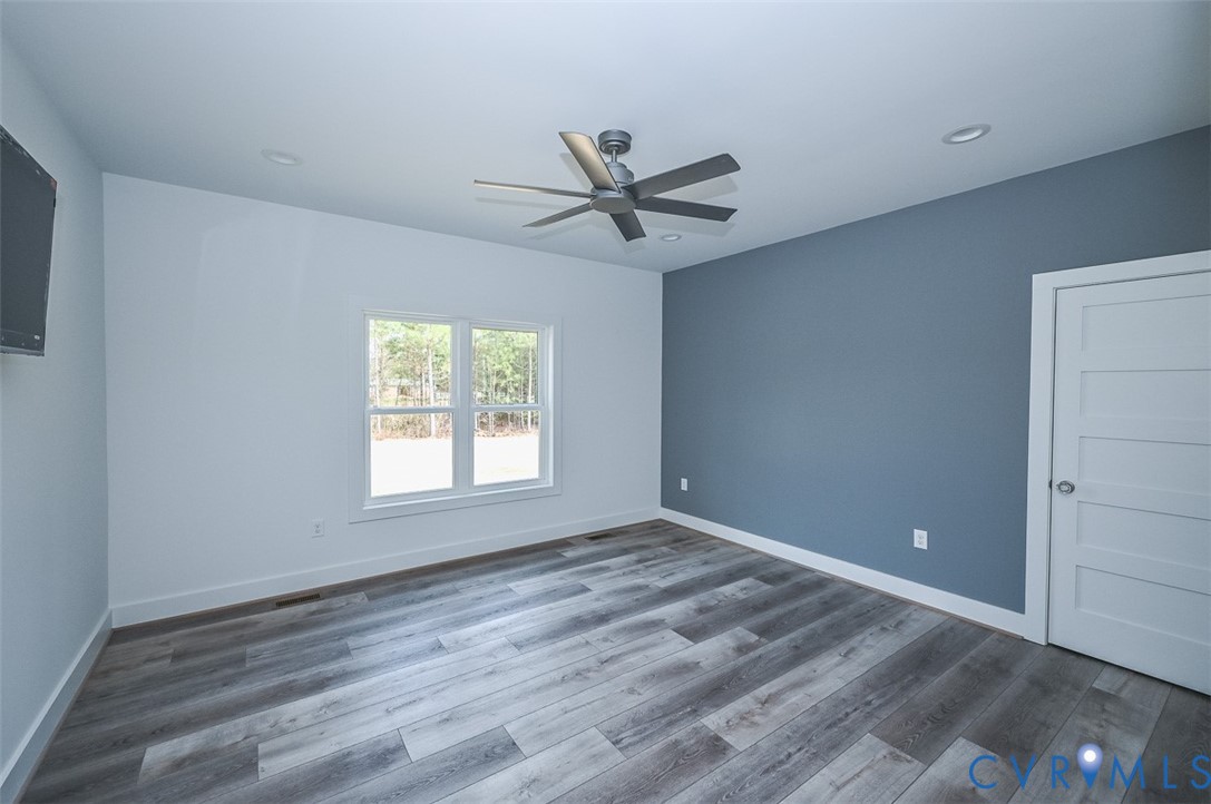 4141 Charles City Road Henrico, VA 23231 - Photo 13 of 35 an empty room with wooden floor ceiling fan and windows