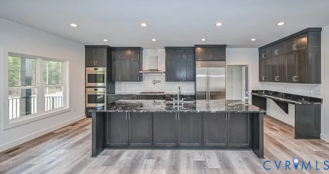 a kitchen with kitchen island granite countertop wooden cabinets and stainless steel appliances