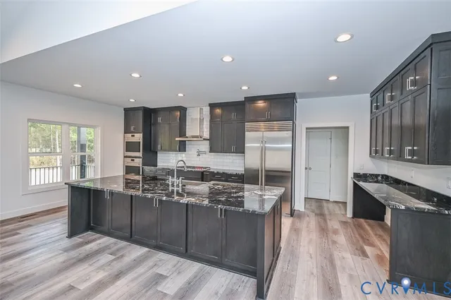 a kitchen with stainless steel appliances granite countertop a refrigerator and a stove