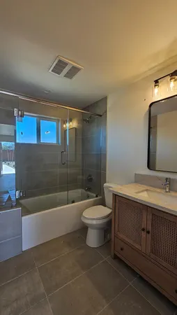 a bathroom with a sink a toilet and shower