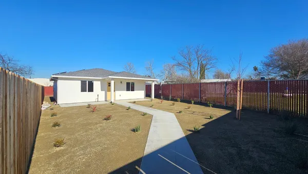 a view of a house with wooden fence