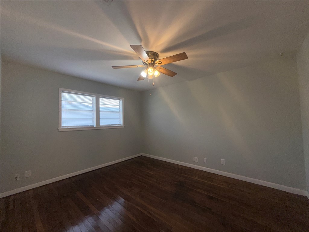 1608 Austin Street Portland, TX 78374 - Photo 17 of 24 a view of an empty room with wooden floor and a ceiling fan