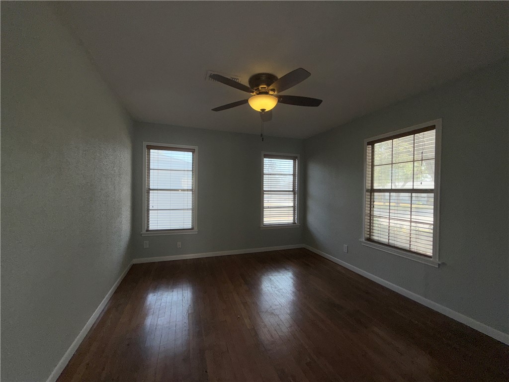1608 Austin Street Portland, TX 78374 - Photo 5 of 24 a view of an empty room with wooden floor and a window