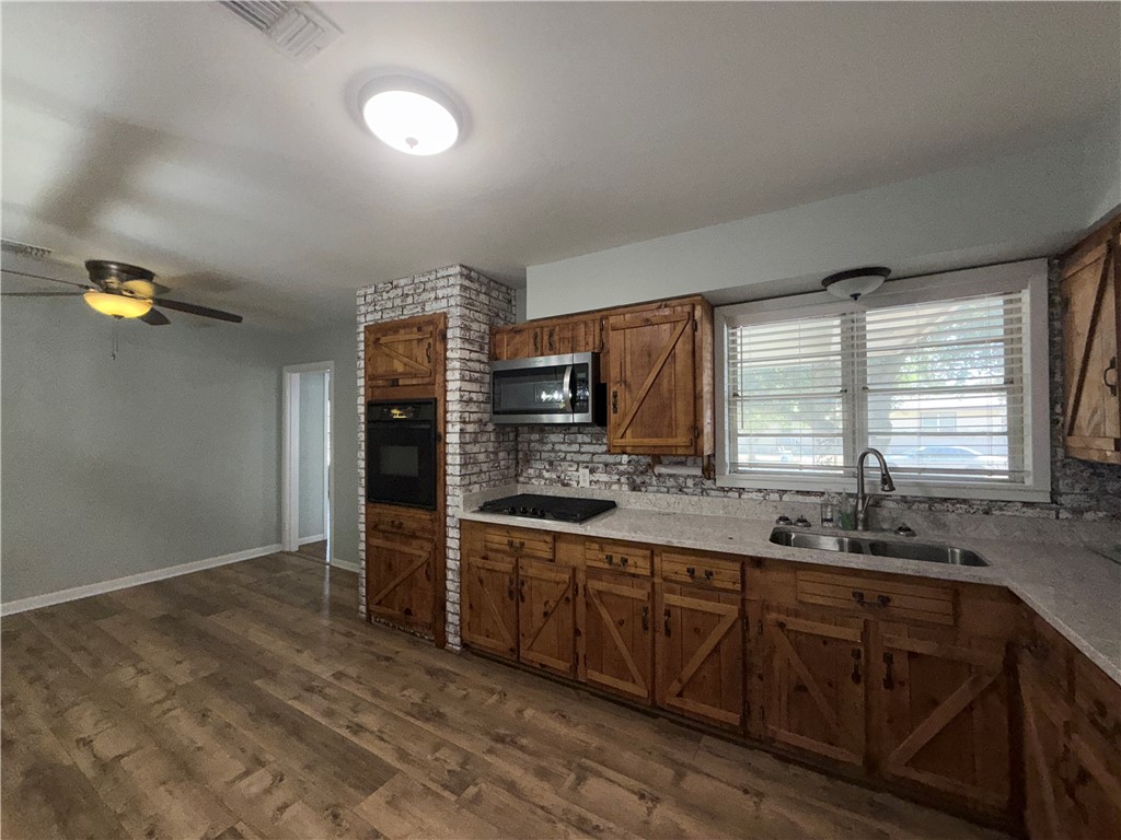 1608 Austin Street Portland, TX 78374 - Photo 8 of 24 a kitchen with stainless steel appliances kitchen island granite countertop a sink and cabinets