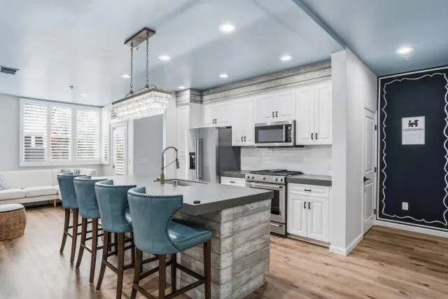 a large kitchen with stainless steel appliances kitchen island granite countertop a stove a sink a dining table and chairs