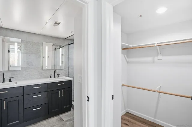 a spacious bathroom with a double vanity sink a mirror and a shower