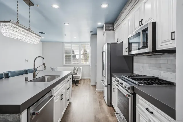 a kitchen with stainless steel appliances granite countertop a sink stove and refrigerator