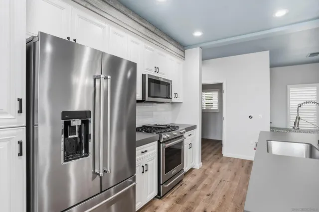 a kitchen with stainless steel appliances granite countertop a refrigerator stove and sink