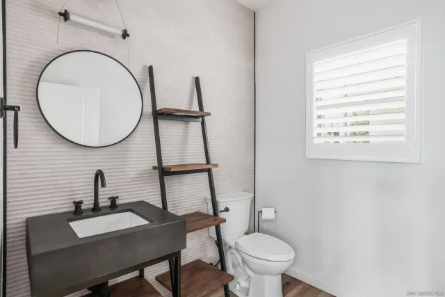 a bathroom with a toilet a sink and a mirror
