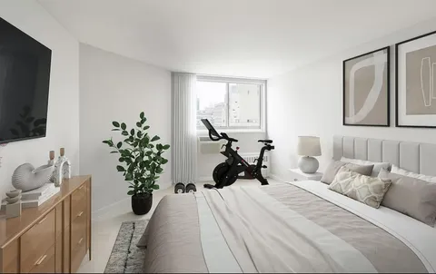 a bedroom with a bed and a potted plant