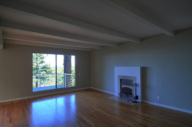 254 Swett Road Woodside, CA 94062 - Photo 8 of 24 an empty room with wooden floor a fireplace and windows