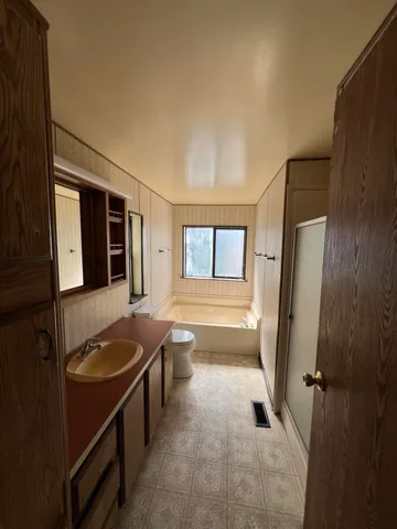 a bathroom with a granite countertop sink and a large mirror
