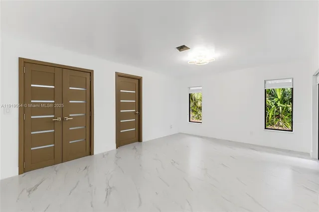 an empty room with windows and closet