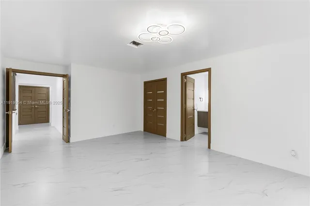 an empty room with closet and mirror