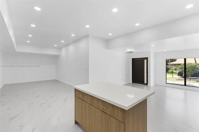 a view of an empty room with wooden floor and windows