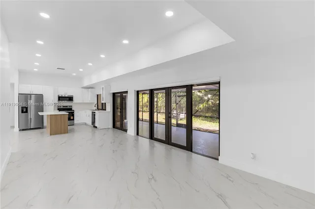a view of an empty room with a kitchen