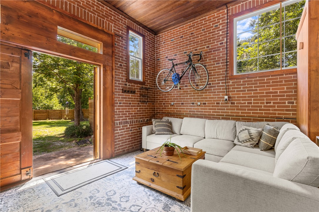 704 Cherry Street Pendleton, SC 29670 - Photo 15 of 28 Exposed brick walls and rich wood accents create an inviting living space with an outdoor connection.