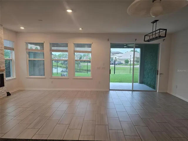 a view of an empty room with glass door and windows