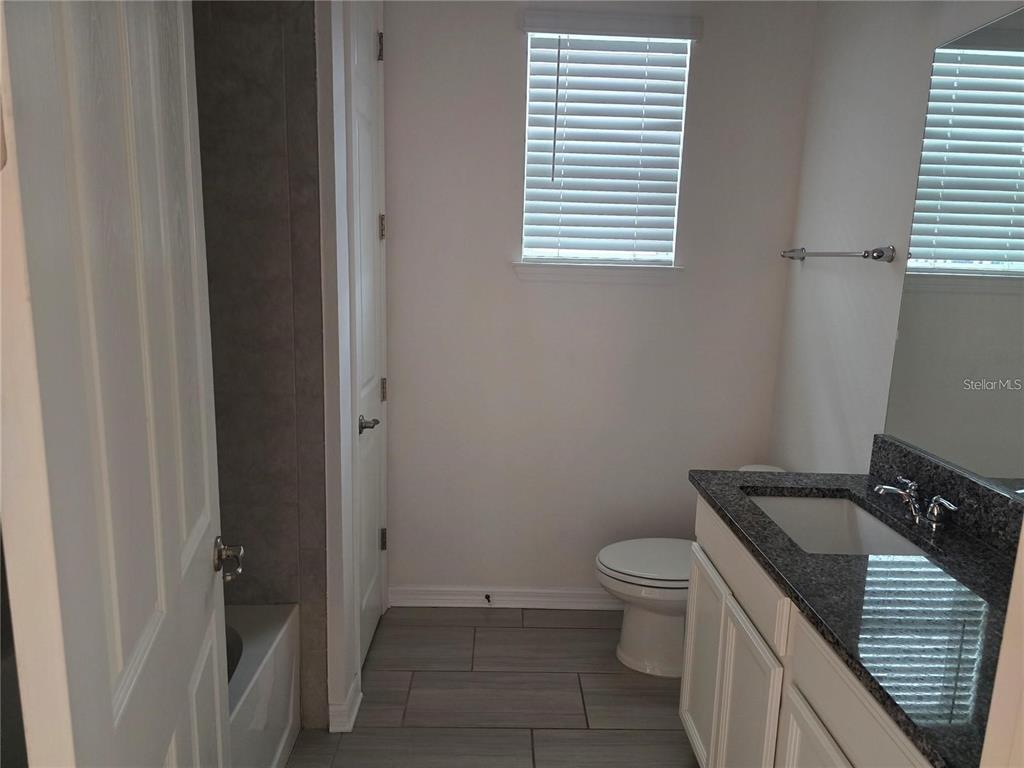 30517 Pecan Valley Loop Wesley Chapel, FL 33543 - Photo 10 of 15 a bathroom with a granite countertop toilet and a sink