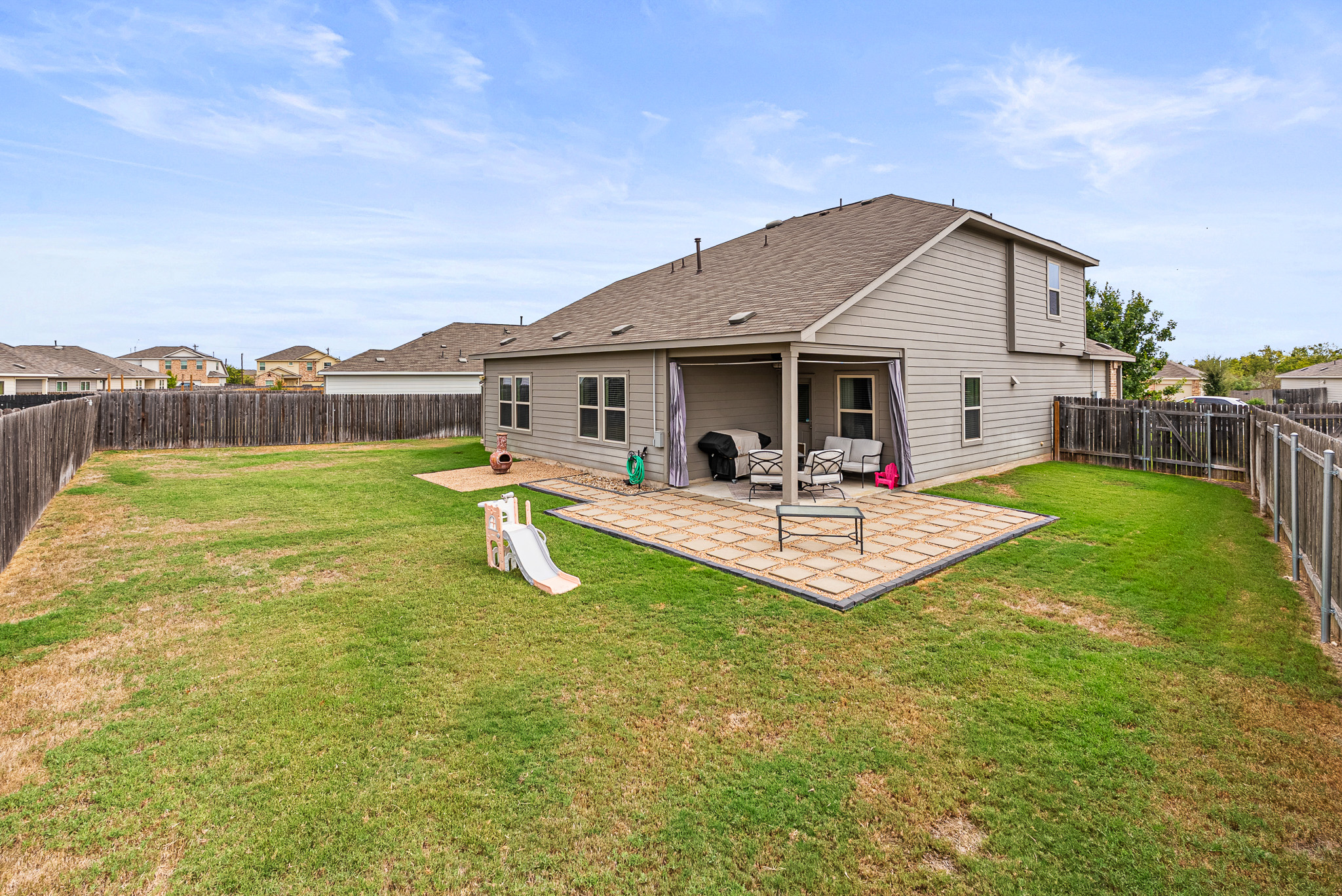 136 Copper Lane Kyle, TX 78640 - Photo 6 of 33 a view of a patio with a table and chairs under an umbrella