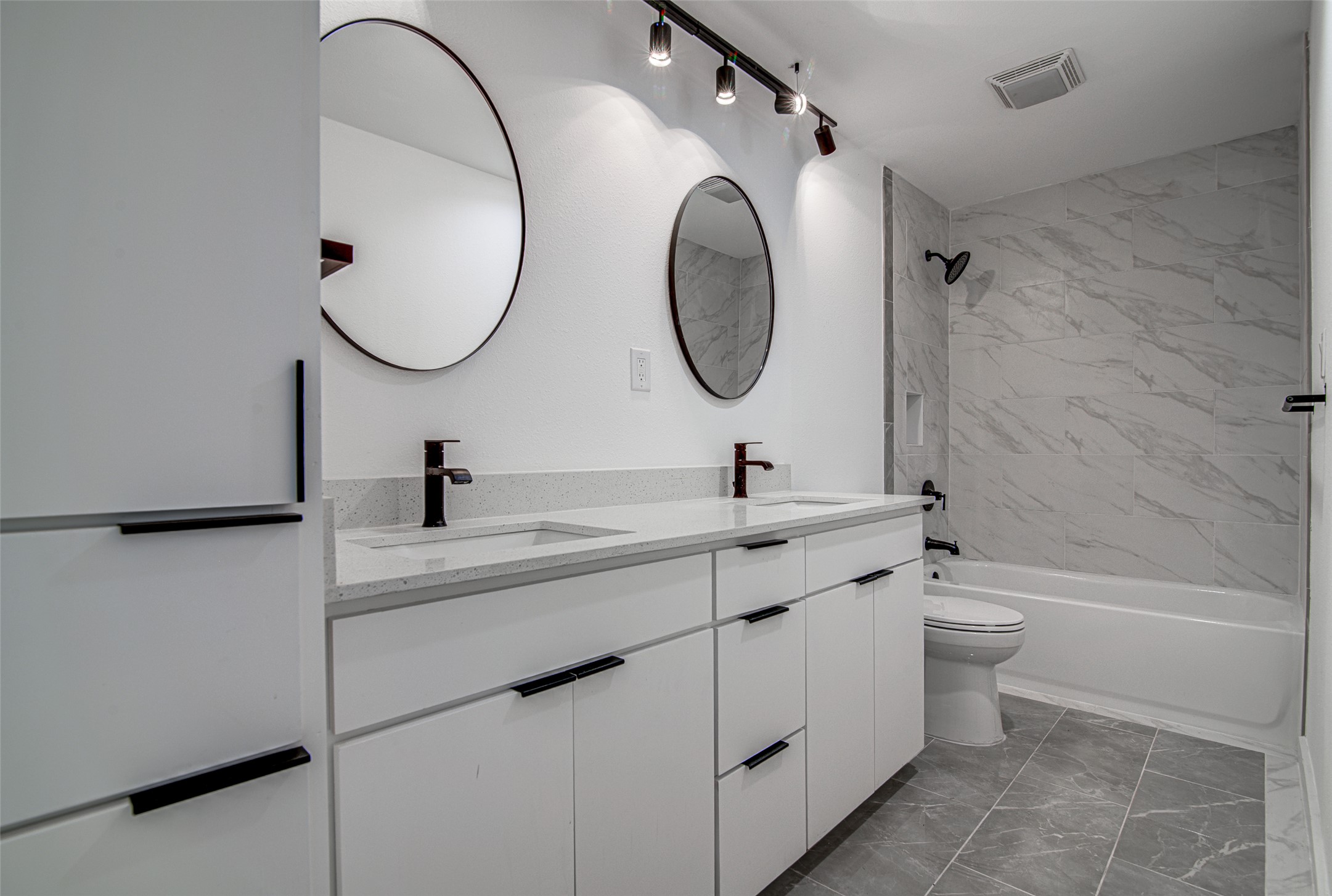 207 Haley Road Johnson City, TX 78636 - Photo 25 of 31 A well-lit bathroom showcases a dual-sink vanity with contemporary fixtures and a tiled shower-tub combination.