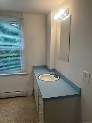 a bathroom with a sink a mirror and a window