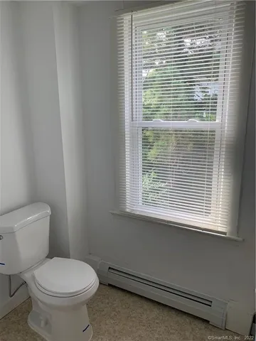 a bathroom with a toilet a window and a shower
