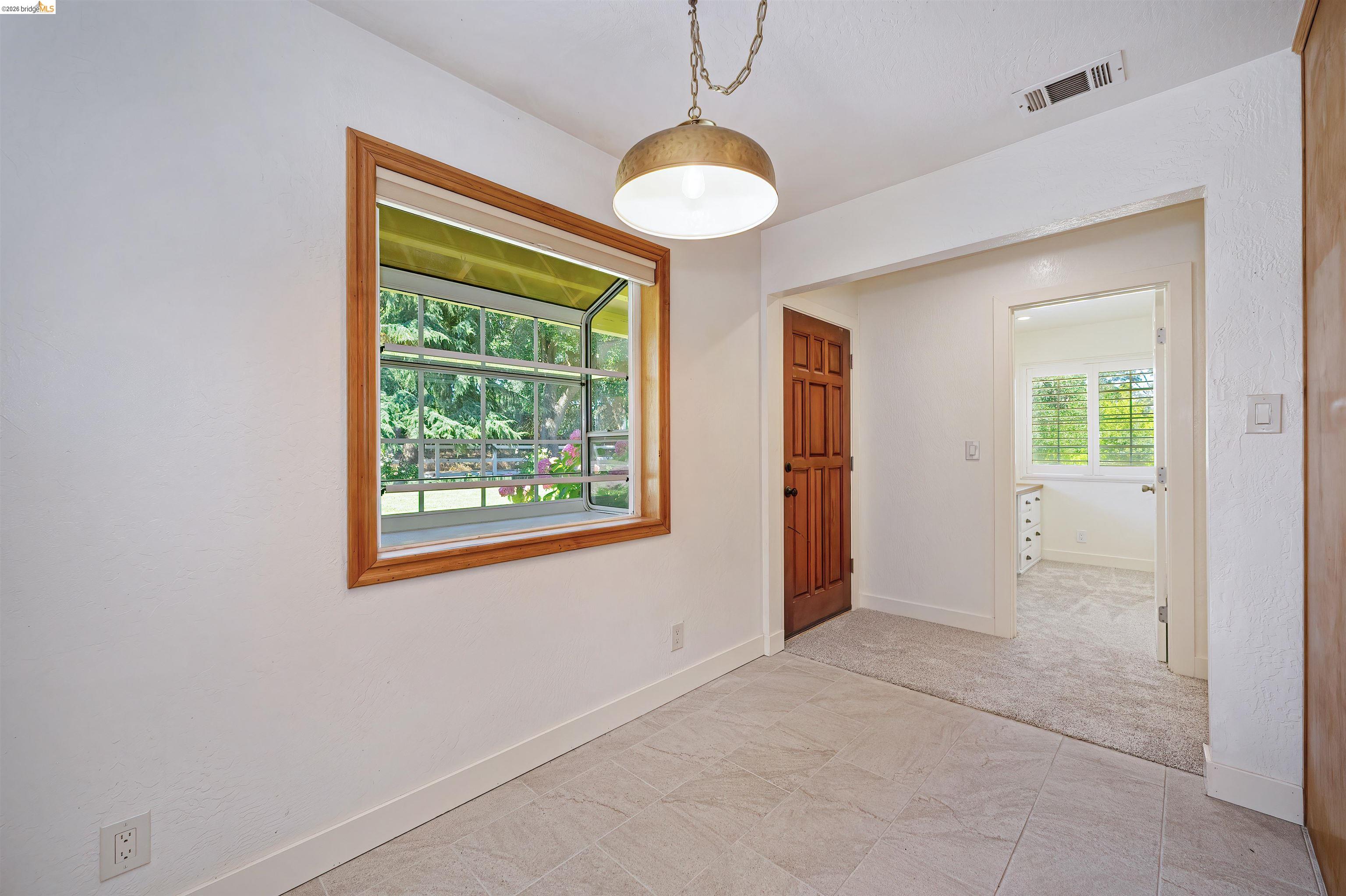 10474 Sheldon Road Elk Grove, CA 95624 - Photo 24 of 83 Interior space with light-toned tiled flooring, a wood-framed window, and a brass-tone ceiling light fixture