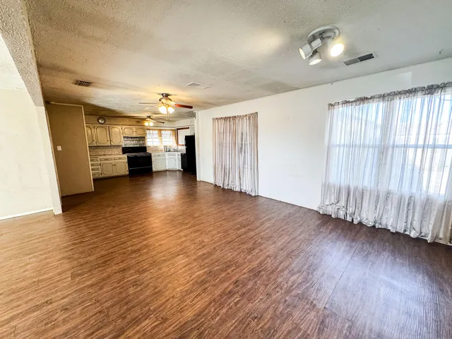 a view of a livingroom with furniture wooden floor and windows