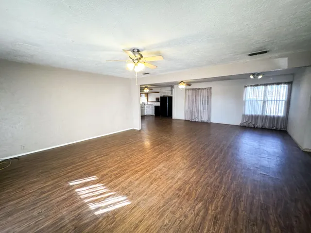 a view of a livingroom with wooden floor and a ceiling fan
