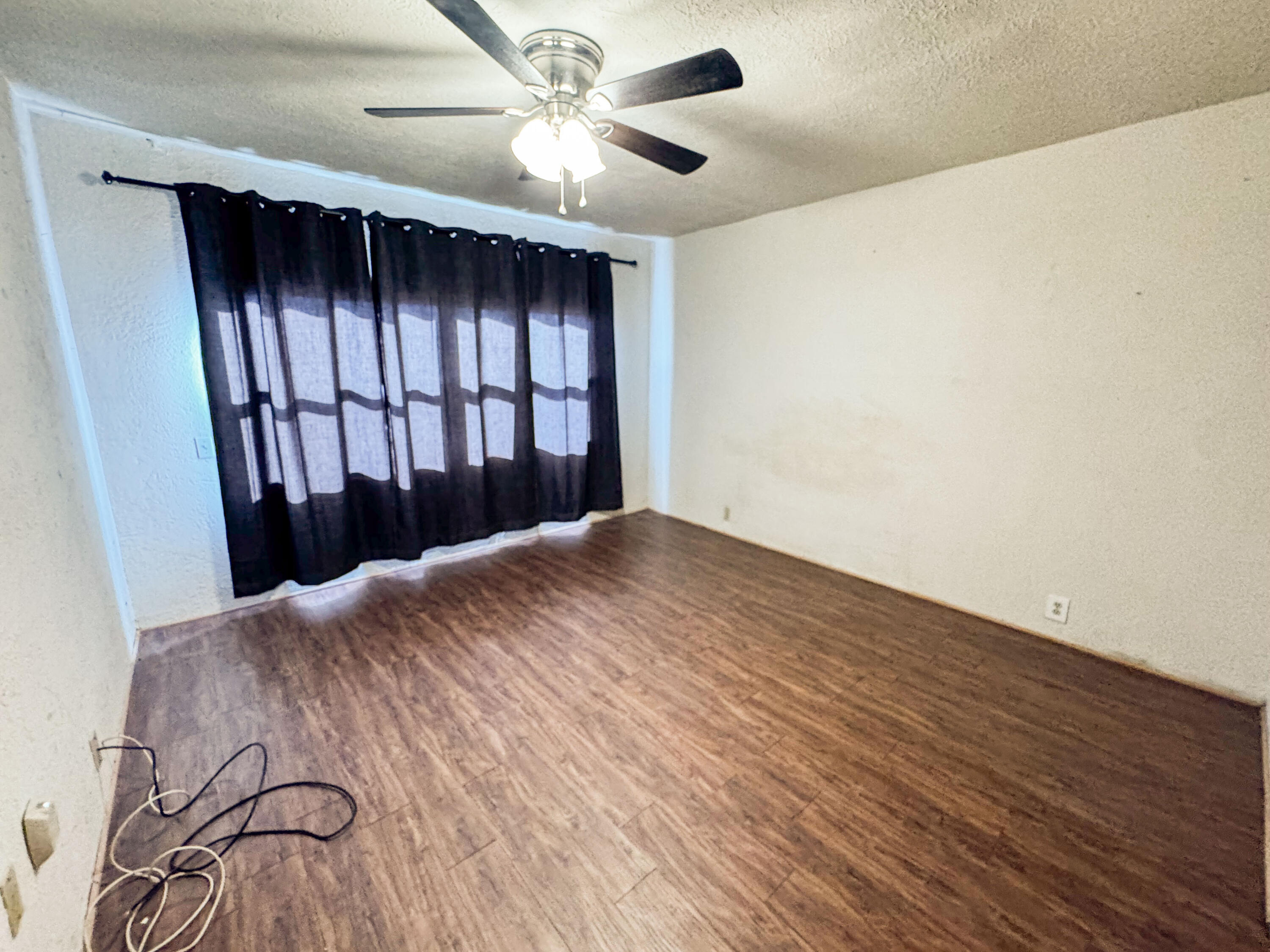 733 East 13th Street Littlefield, TX 79339 - Photo 6 of 15 wooden floor in an empty room with a window