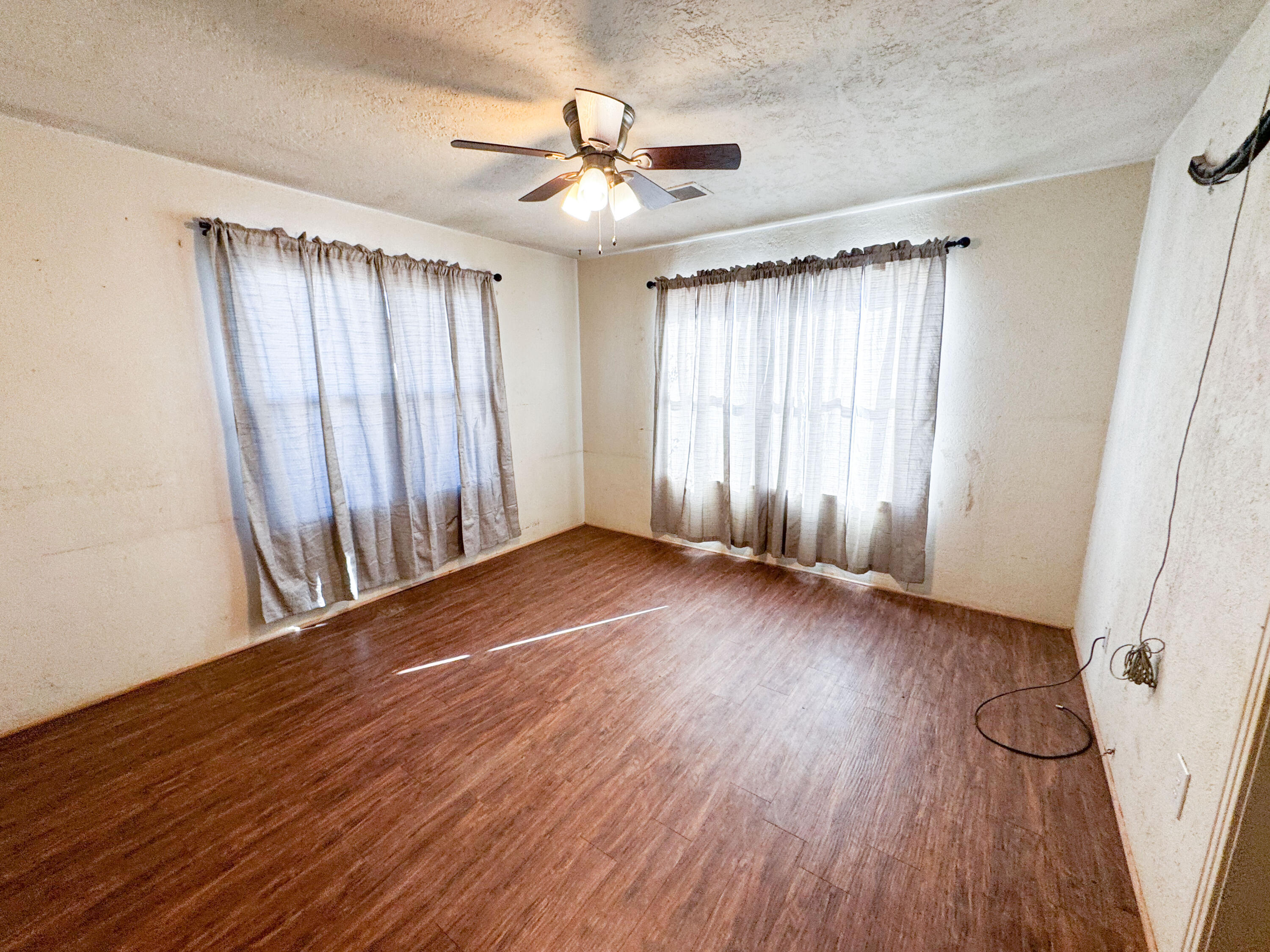 733 East 13th Street Littlefield, TX 79339 - Photo 10 of 15 an empty room with wooden floor and windows
