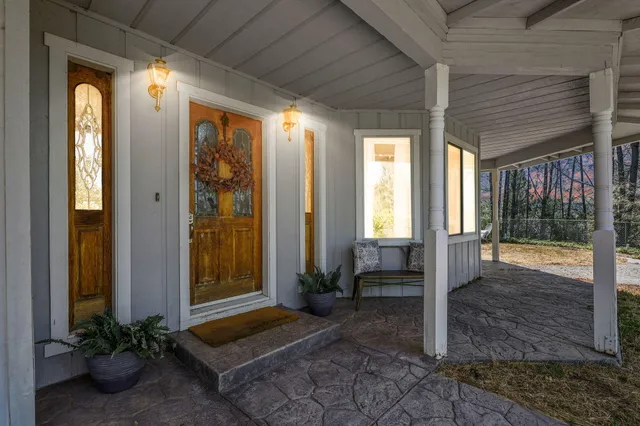 an aerial view of residential house with outdoor space and trees all around